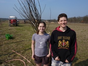 Olivia and Avery Swarthout take a break from planting a pear tree. Credit: Brian Swarthout, March, 2012.
